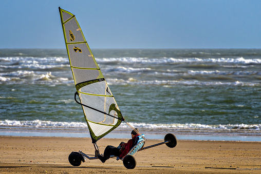 Unidentified man landsailing on the beach of Punta Umbria, Huelva, Spain, with strong winds.