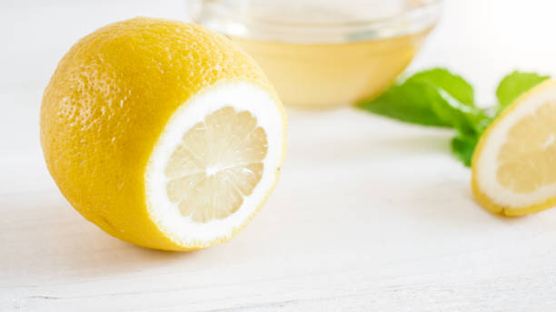 istock Closeup image of cut fresh lemon lying on white table 952388746