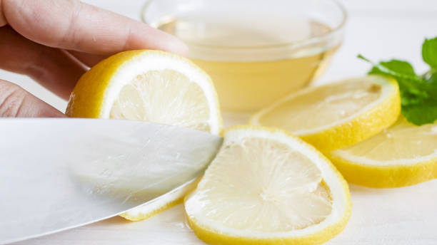 istock Macro image of fresh lemon being cut with sharp knife 952388888
