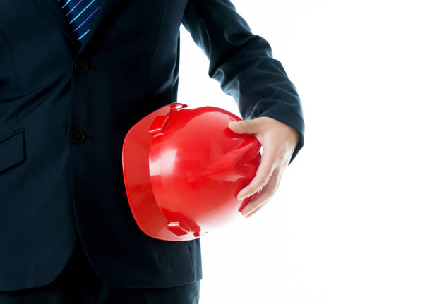 Businessman holding a hardhat under his arm.