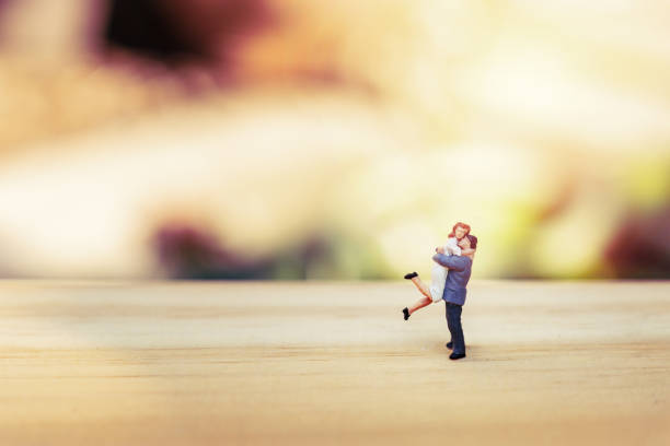 miniature couple on wooden with bokeh background
