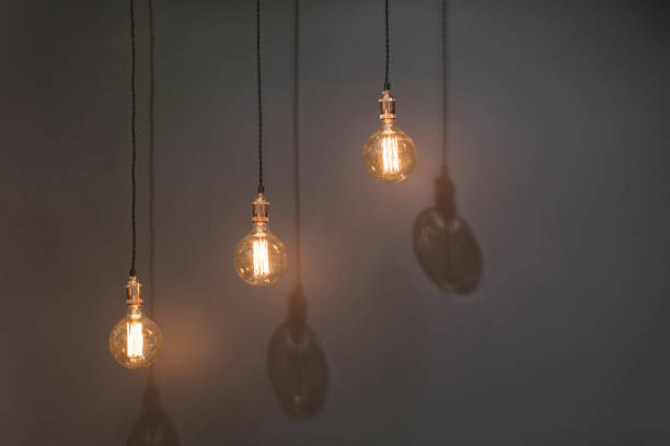 istock Three classic Edison lights bulb isolated on black background with space 952394112
