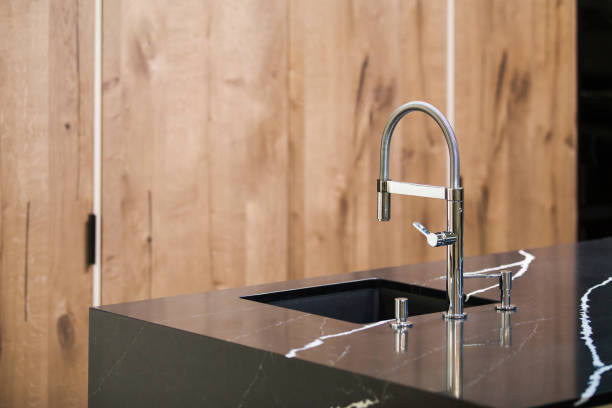 istock Kitchen faucet, modern kitchen in loft style, black marble table, wooden luxury kitchen 952394340