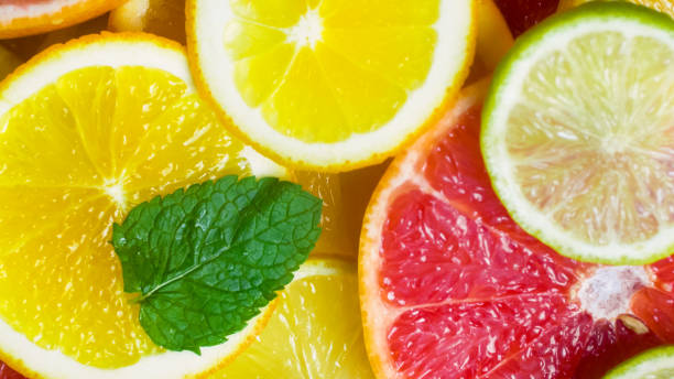 istock Closeup image of mint leaf on freshly cut oranges anfd grapefruits 952397596
