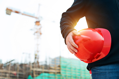 Engineer holding a hardhat under his arm.