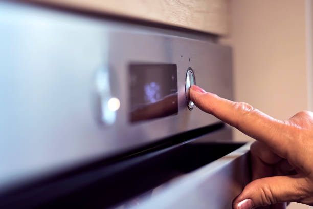 istock Female hand turns on  microwave 952402840