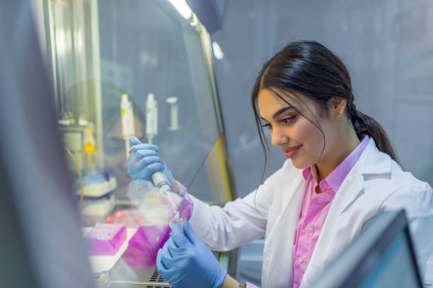 Photo of Female scientist Female scientist with equipment and science experiments, Laboratory glassware containing chemical liquid, science research background. Photo of a brown hair student of chemistry working in laboratory. Scientist with dropper working at the laboratory fume cupboard stock pictures, royalty-free photos & images