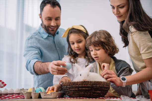 istock young family preparing for easter holiday with rabbit sitting on table 952413474