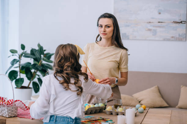 istock young mother and daughter painting easter eggs at home 952413986