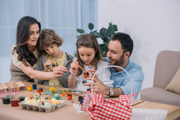 istock young family painting eggs for easter at home 952415514