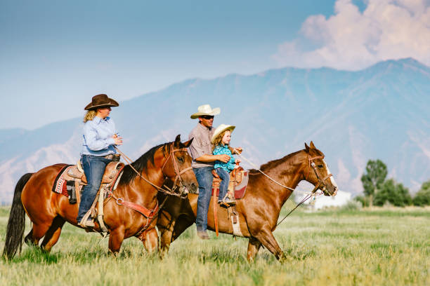 cowboy family riding cavalli insieme - teaching child horseback riding horse foto e immagini stock