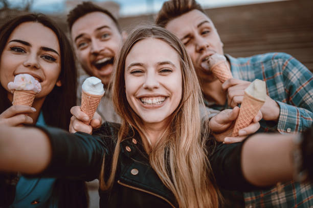 istock Smiling Friends Holding Cones with Ice Cream and Taking Selfie 952415912