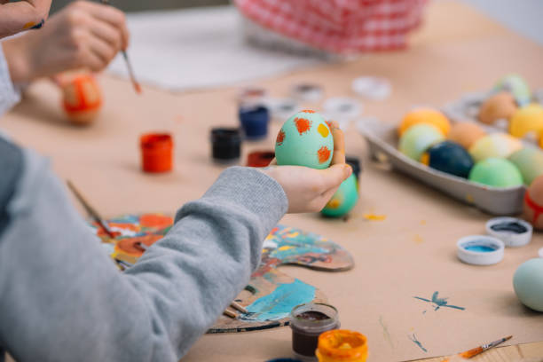 istock cropped shot of kid painting easter eggs 952420546