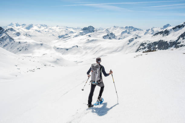 alpinista a piedi sulla valle di montagna innevata - snowshoeing hiking mountain winter foto e immagini stock