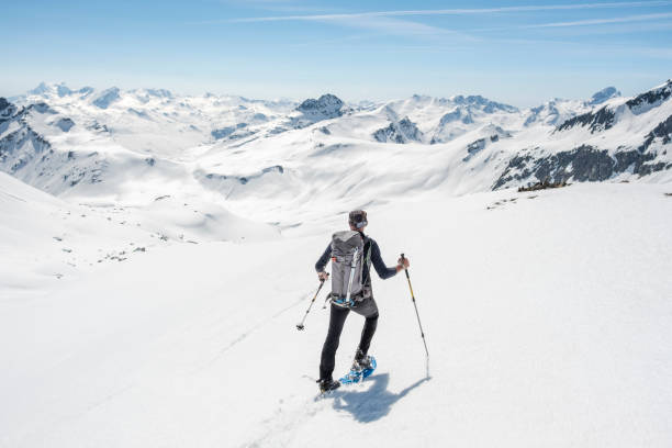 альпинист, идущих по заснеженной горной долине - snowshoeing hiking mountain winter стоковые фото и изображения