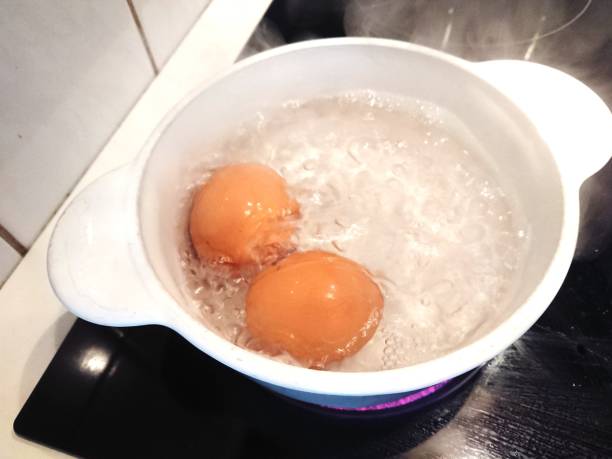 Eggs in boiling water Eggs in boiling water with steam boiled egg photos stock pictures, royalty-free photos & images