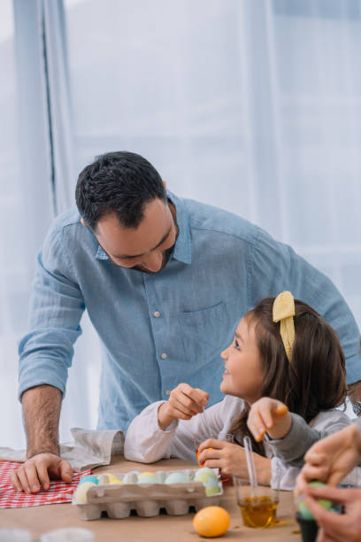 istock young father painting easter eggs with daughter 952426676