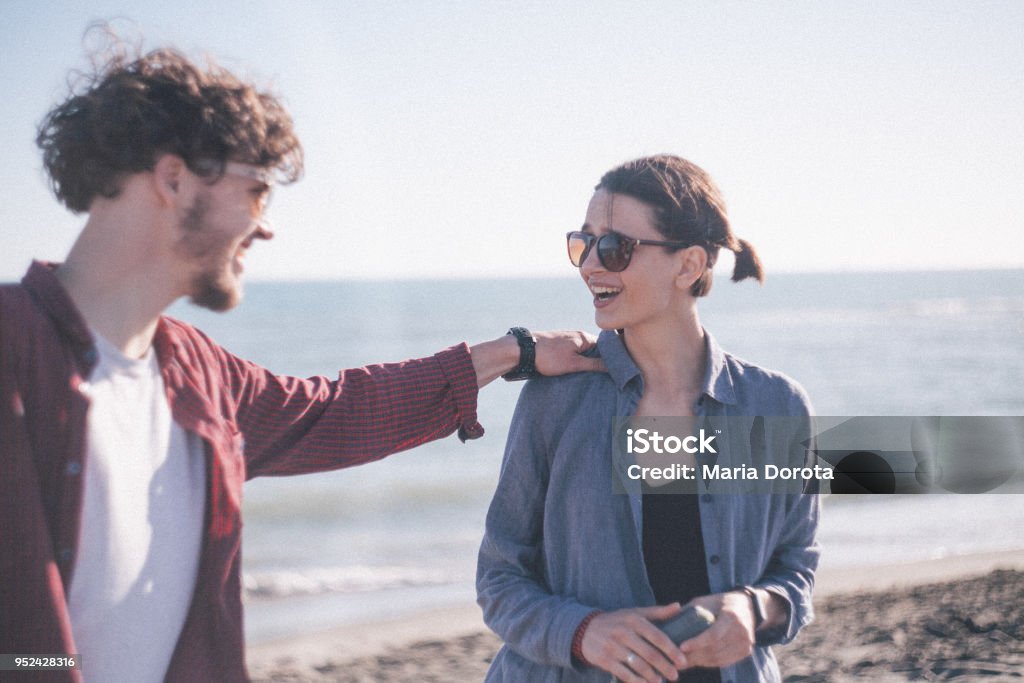 Couple having fun at sunny beach Portrait of young lovely caucasian couple having fun at sunny beach. Hand On Shoulder Stock Photo