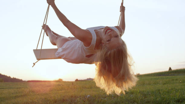 istock LENS FLARE CLOSE UP: Young blonde woman in white looking back and smiling 952437370