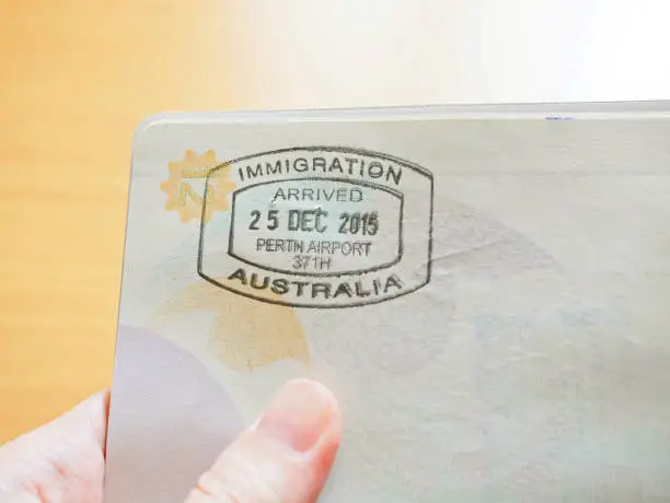 Photo of Hand holding passport with Australian immigration stamp