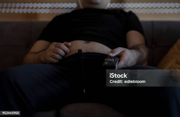 Overweight Man Watching Tv Stock Photo - Download Image Now - Bad Posture, Sofa, Men