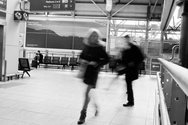 passeggeri in una stazione ferroviaria del regno unito - business blurred motion text messaging defocused foto e immagini stock