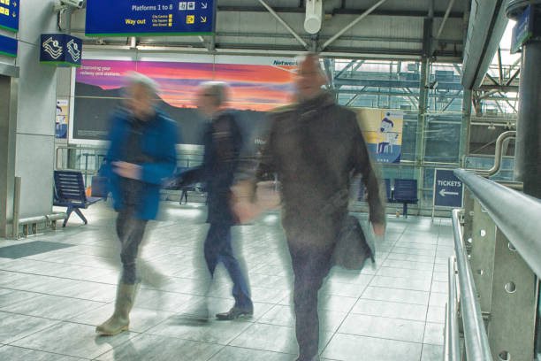 passengers at a uk railway station - business blurred motion text messaging defocused imagens e fotografias de stock