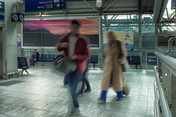 passeggeri in una stazione ferroviaria del regno unito - business blurred motion text messaging defocused foto e immagini stock