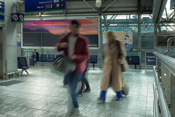 passengers at a uk railway station - business blurred motion text messaging defocused imagens e fotografias de stock