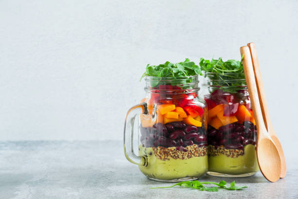 istock rainbow colored salad in jars on the table. with beans, fresh ve 952476268