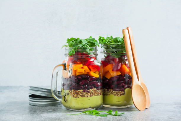 istock rainbow colored salad in jars on the table. with beans, fresh ve 952476288