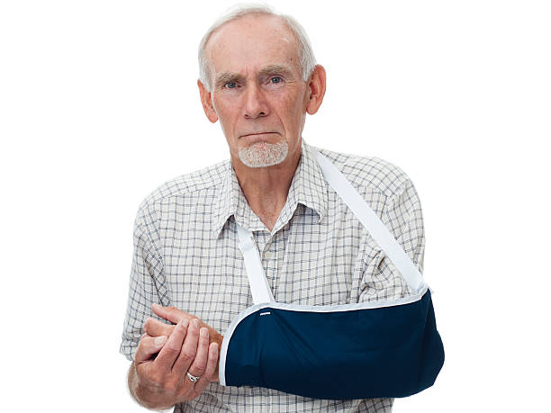homme senior avec bras en bandoulière - physical injury men orthopedic equipment isolated on white photos et images de collection
