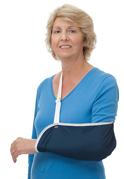 Senior woman with left arm in sling stock photo