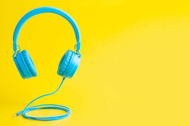 Bright blue headphones on yellow stock photo