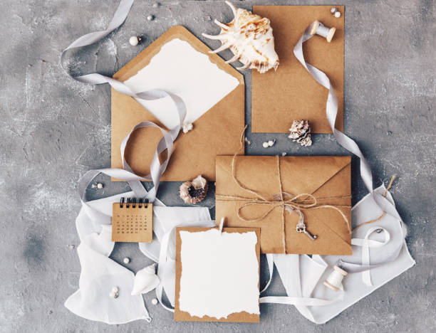istock Mockup wedding invitation flat lay. Craft paper with olive brunch on stone background 952491368