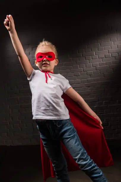 female child flying in red superhero mask