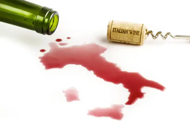 from a bottle comes out of red wine drawing a map of Italy