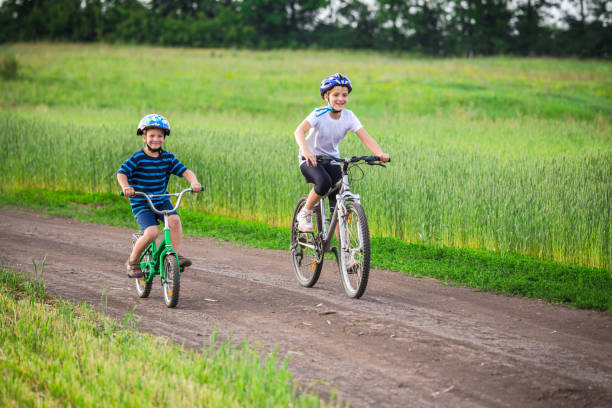 istock Two kids riding on bikes on rural road 952539648