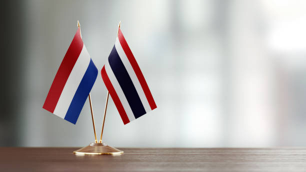 istock Dutch And Thai Flag Pair On A Desk Over Defocused Background 952595476