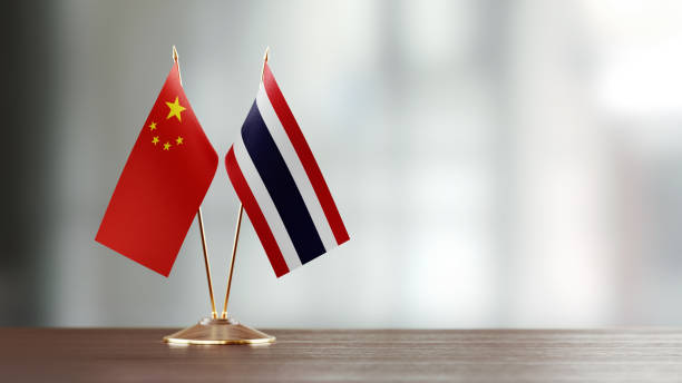 istock Chinese And Thai Flag Pair On A Desk Over Defocused Background 952607132