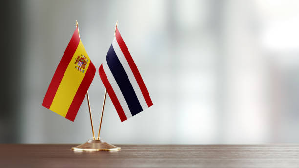 istock Spanish And Thai Flag Pair On A Desk Over Defocused Background 952607996