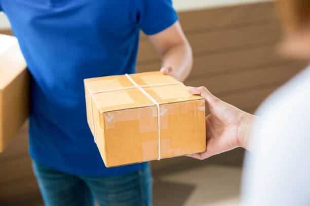 istock Delivery man delivering a parcel to a woman 952625232