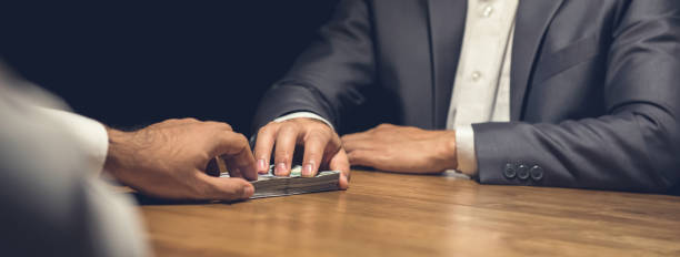 Dishonest businessman secretly giving money to his partner in the dark Dishonest businessman secretly giving money to his partner in the dark - bribery and venality concepts, panoramic web banner sign lie liar stock pictures, royalty-free photos & images