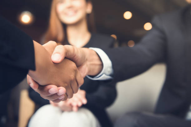 uomini d'affari che si stringono la mano dopo l'incontro in un bar - partnership foto e immagini stock