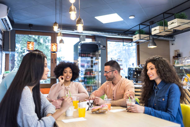 istock Young people talking and eating ice cream and donuts 952625670