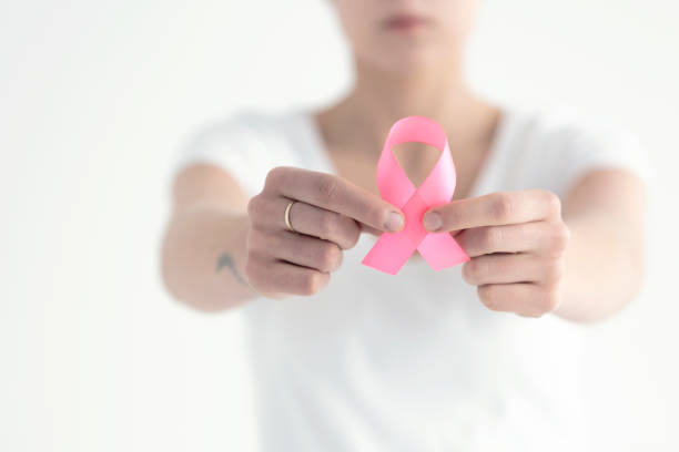Campaign against breast cancer Campaign against breast cancer with woman holding pink ribbon chest tattoo pain stock pictures, royalty-free photos & images