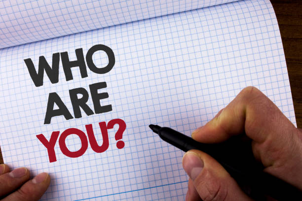 Writing note showing  Who Are You Question. Business photo showcasing Introduce or Identify Yourself Tell your Personal Story written by Man on Notebook Book holding Marker on the wooden background