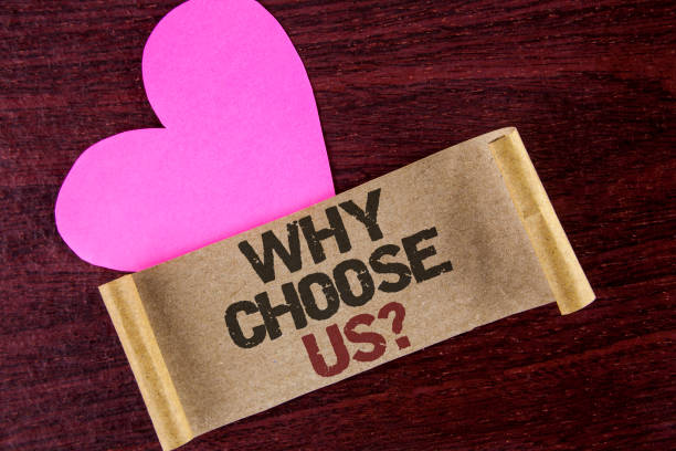 istock Writing note showing  Why Choose Us Question. Business photo showcasing Reasons to select our Services Products or Offers written on Cardboard paper on wooden background Heart next to it. 952643668
