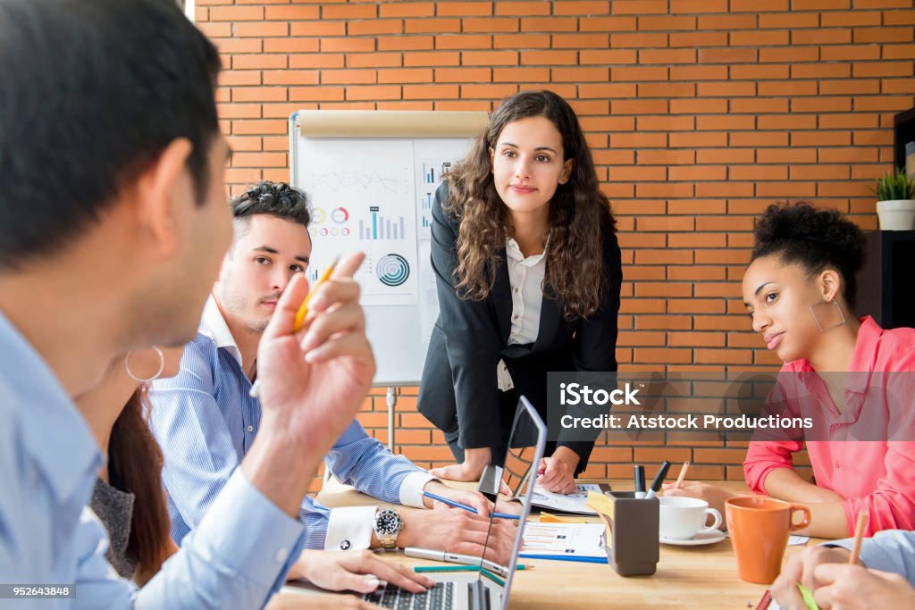 Female business team leader paying attention to her colleague expressing opinion in a meeting Female business team leader paying attention to her colleague expressing opinion in sales meeting Asking Stock Photo