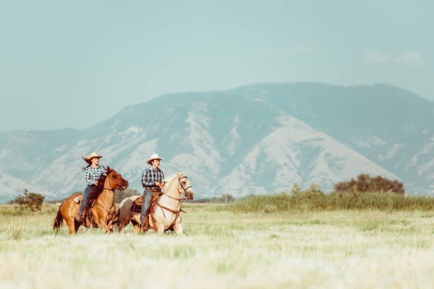 Cowboy and cowgirl horseback riding in Utah
